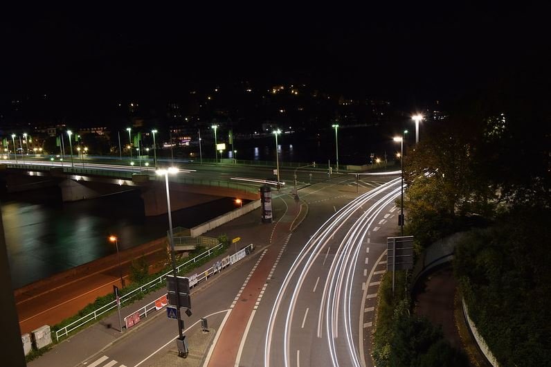 Ein Langzeitbelichtung einer Straße bei Nacht. Die Lichter der Fahrzeuge sind so als Linien zu erkennen.