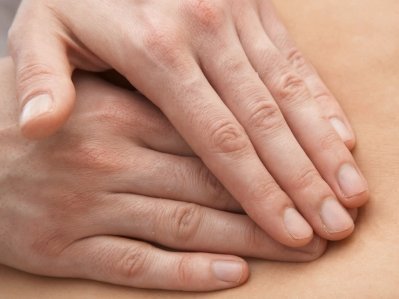 Zwei Hänge liegen mit den Fingerspitzen übereinander auf einem Bauch