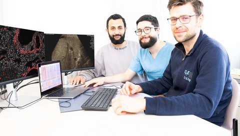 Ahmed Alaswad, Alejandro Campos-Murguia und Dr. Bastian Engel sitzen vor Monitoren mit mikroskopischen Abbildungen.