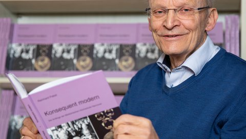 MHH-Professor Dr. Reinhard Pabst hält sein Buch über die Anfänge der Hochschule in den Händen. 