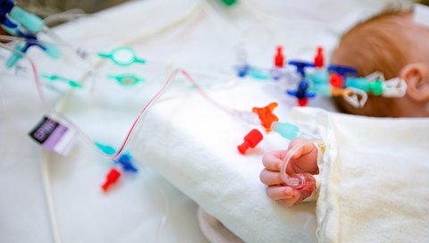 Die Hand eines Säuglings mit einem intravenösen Zugang