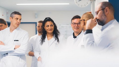 A doctor in conversation with colleagues.