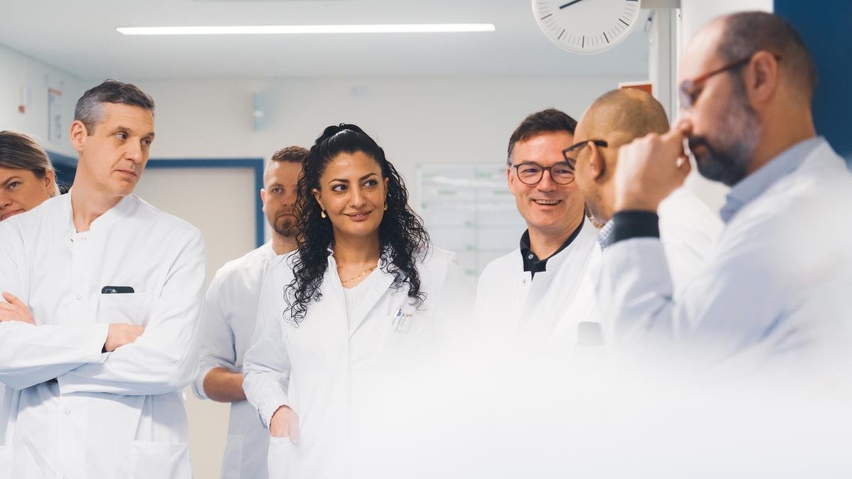 A doctor in conversation with colleagues.