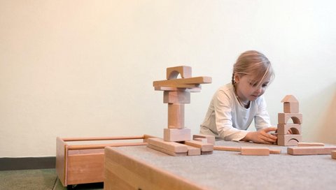 Ein kleines Mädchen spielt mit Bauklötzen