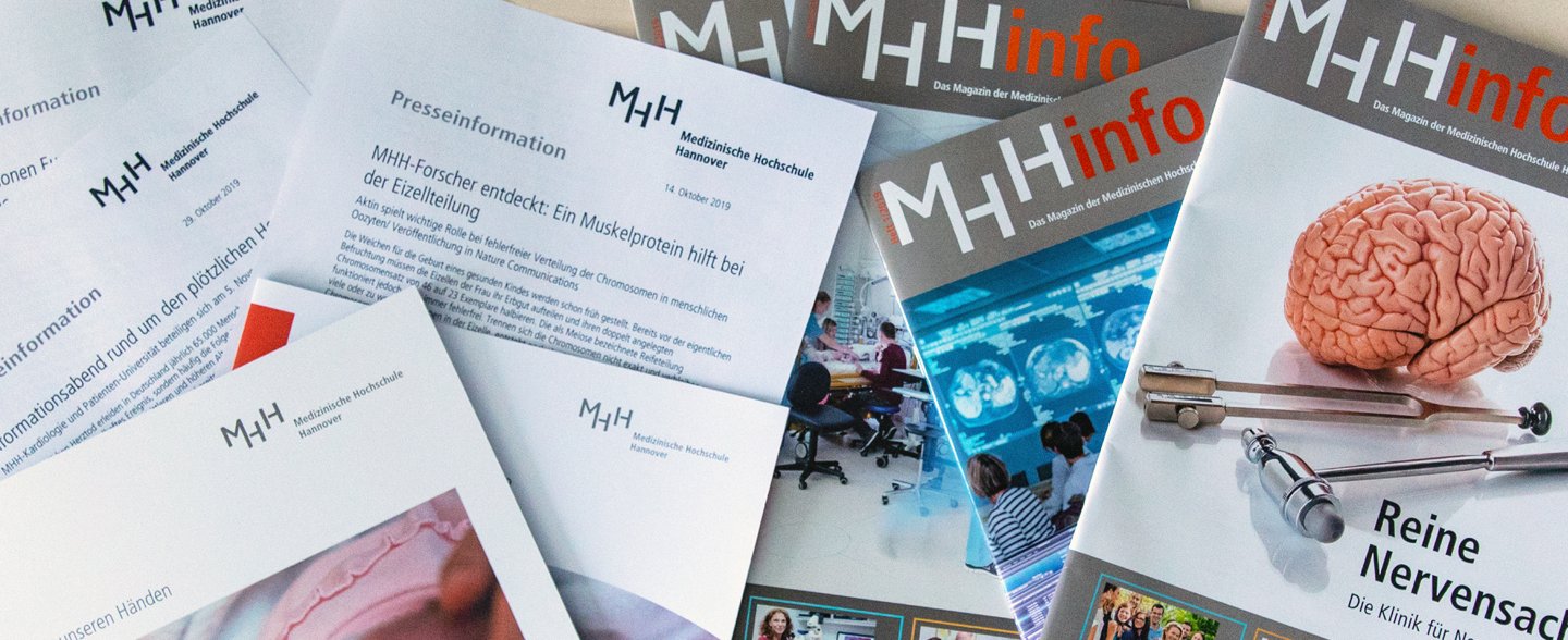 Mehrere MHHinfo-Magazine und andere Zettel mit der Aufschrift Presseinformation liegen auf einem Tisch. 