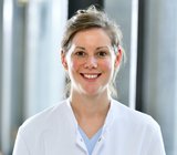 Porträtbild von Valerie Ohlendorf, die einen weißen Arztkittel trägt. 