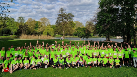 All MHH participants of the relay teams stand together for a group picture on a green meadow. 