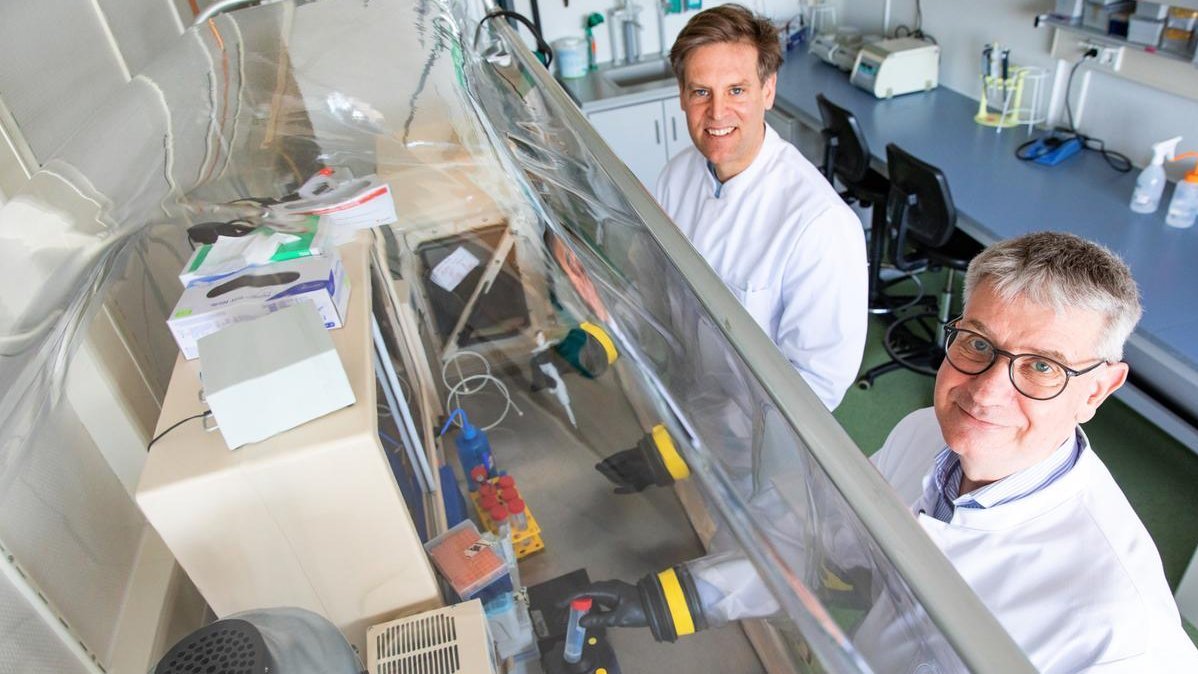 Prof. Dr. Dirk Schlüter (right) and associate professor Dr. Marius Vital stand at an oxygen-free laboratory bench.