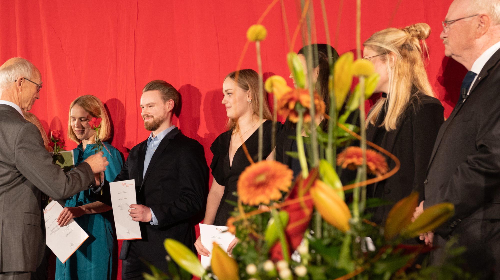 Absolventinnen und Absolventen bekommen eine rote Rose.