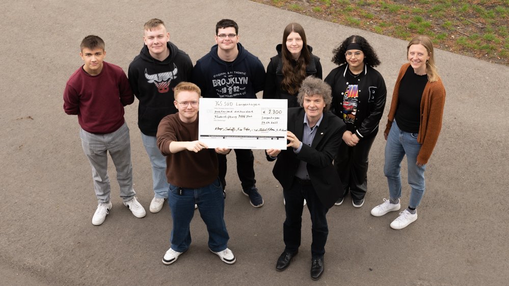Schülerinnen und der Leiter der Stabsstelle Fundraising der Medizinischen Hochschule Hannover halten einen Spendenscheck in die Höhe
