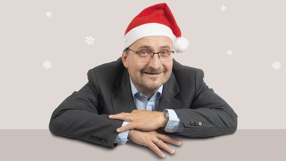 Sänger und Pianist Burkhard Bauche trägt eine Weihnachtsmütze und lächerlt freundlich in die Kamera.