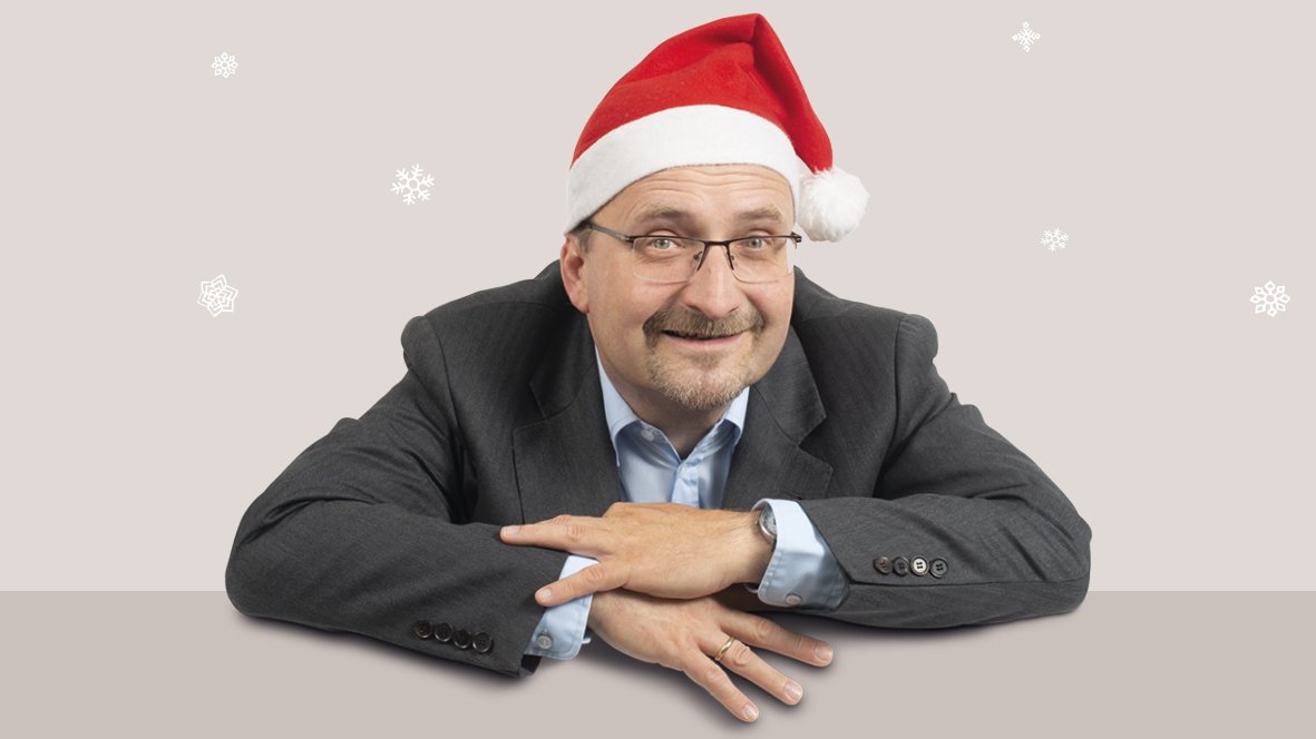 Sänger und Pianist Burkhard Bauche trägt eine Weihnachtsmütze und lächerlt freundlich in die Kamera.