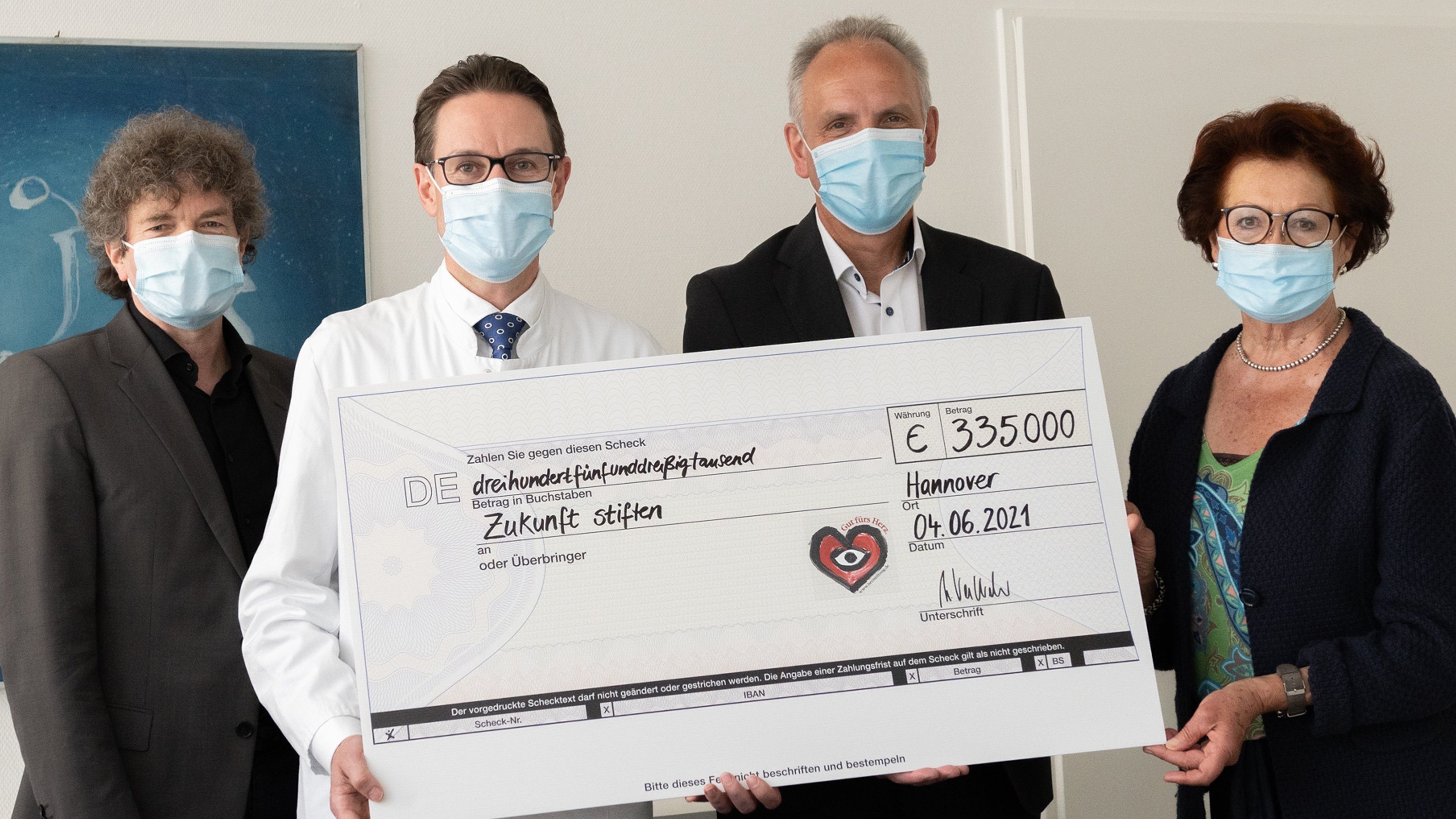 Dr. Eckhard Schenke, Professor Johann Bauersachs sowie Martin Vestweber und Gisela Neubauer von der Deutschen Herzstiftung halten gemeinsam einen Spendenscheck hoch. 