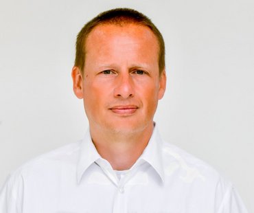 Copyright: Tom Figiel Porträtbid von Markus Flentje, der ein weißes Hemd mit Kragen trägt.