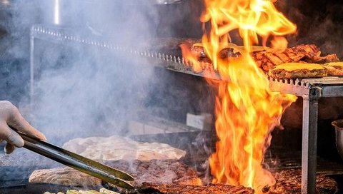 Flames shoot up from a grill