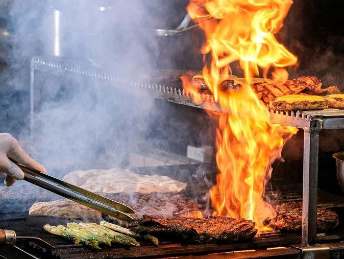 Flames shoot up from a grill