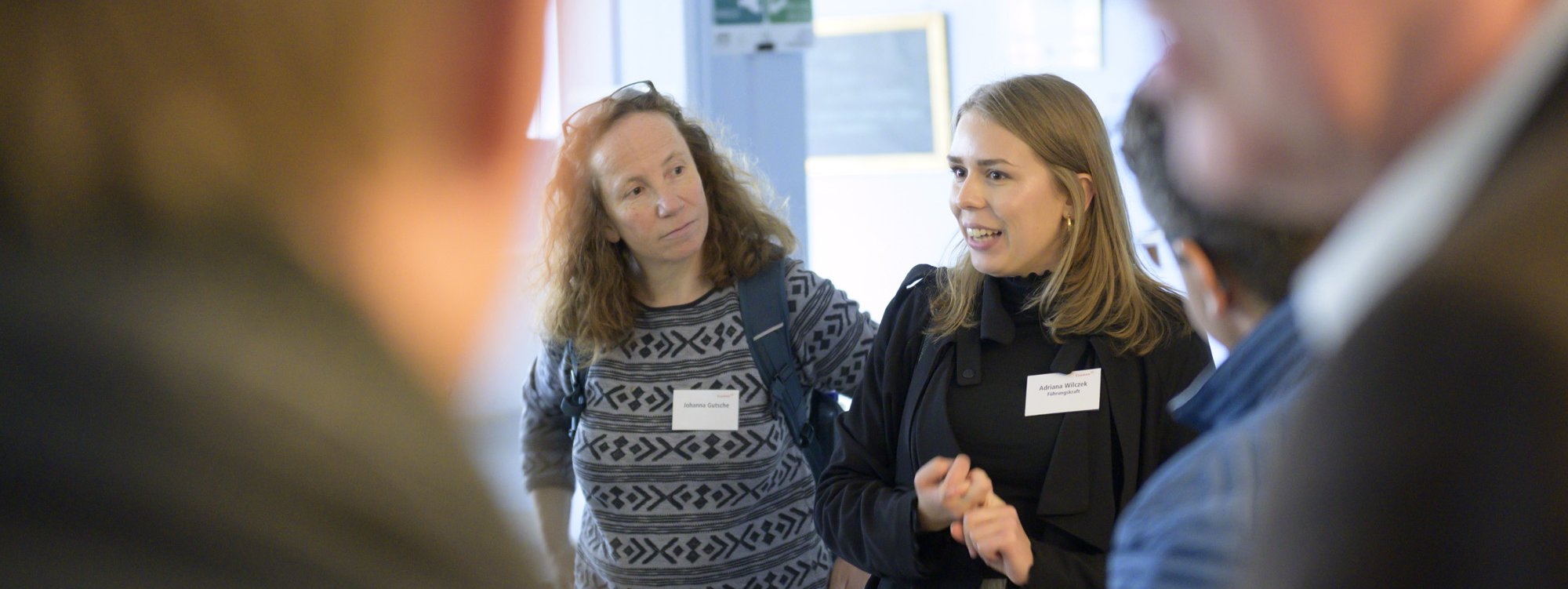 Adriana Wilczek zeigt ihrer Gruppe das Studierendencafé Wohnzimmer