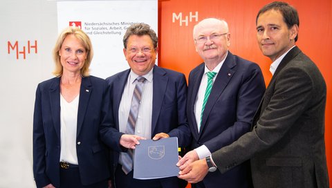 Professorin Dr. Anette S. Debertin, Minister Dr. Andreas Philippi, Professor Dr. Michael Manns und Hanno Kummer (von links) stehen nebeneinander. 