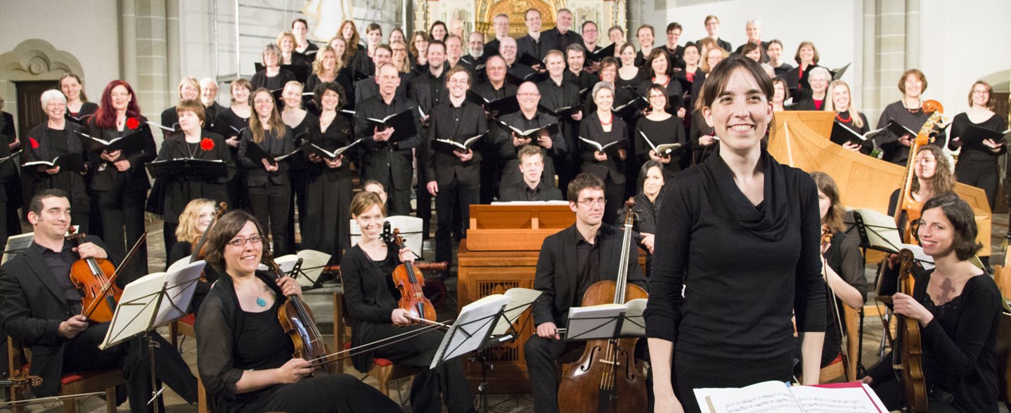 Der MHH-Chor hat sich mit dem MHH-Symphonieorchester in einer Kirche vor dem Altar aufgestellt. 