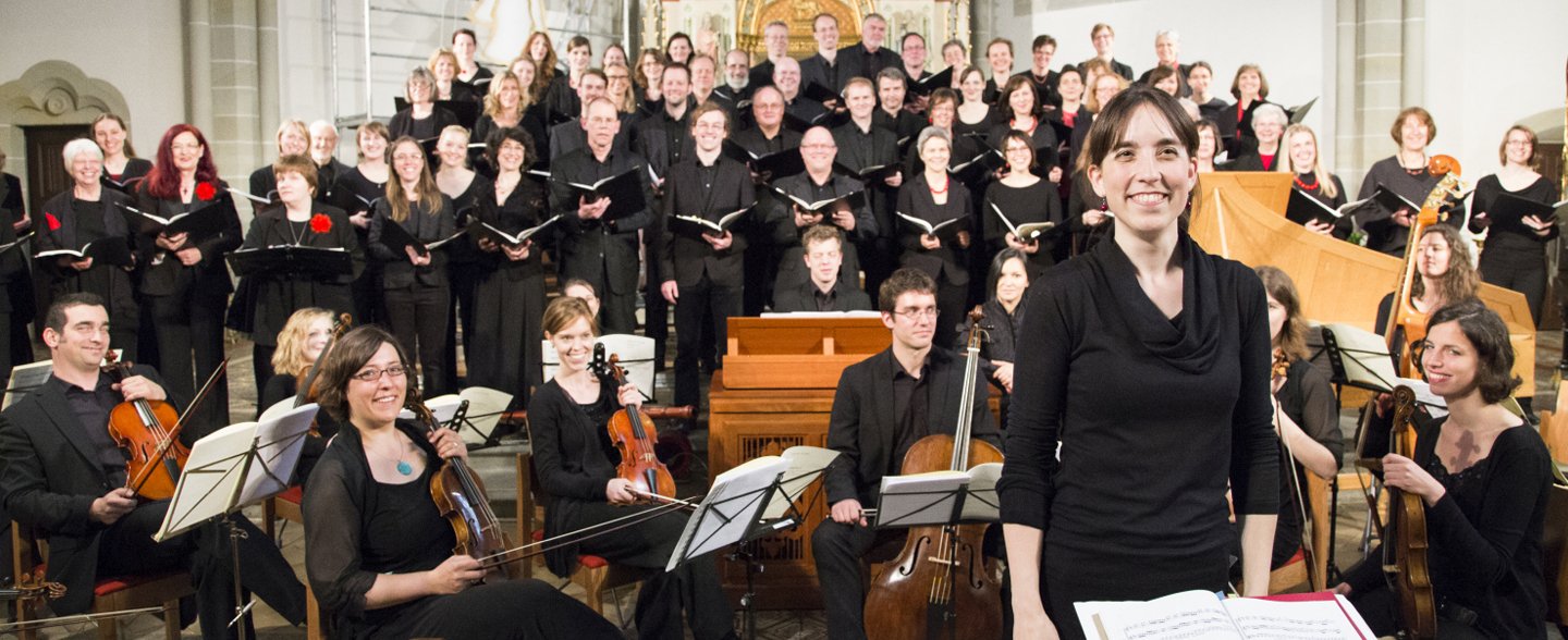 Der MHH-Chor hat sich mit dem MHH-Symphonieorchester in einer Kirche vor dem Altar aufgestellt. 