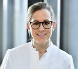 Porträtbild von Anna-Lena Weber, die einen weißen Arzt-Kittel trägt. 