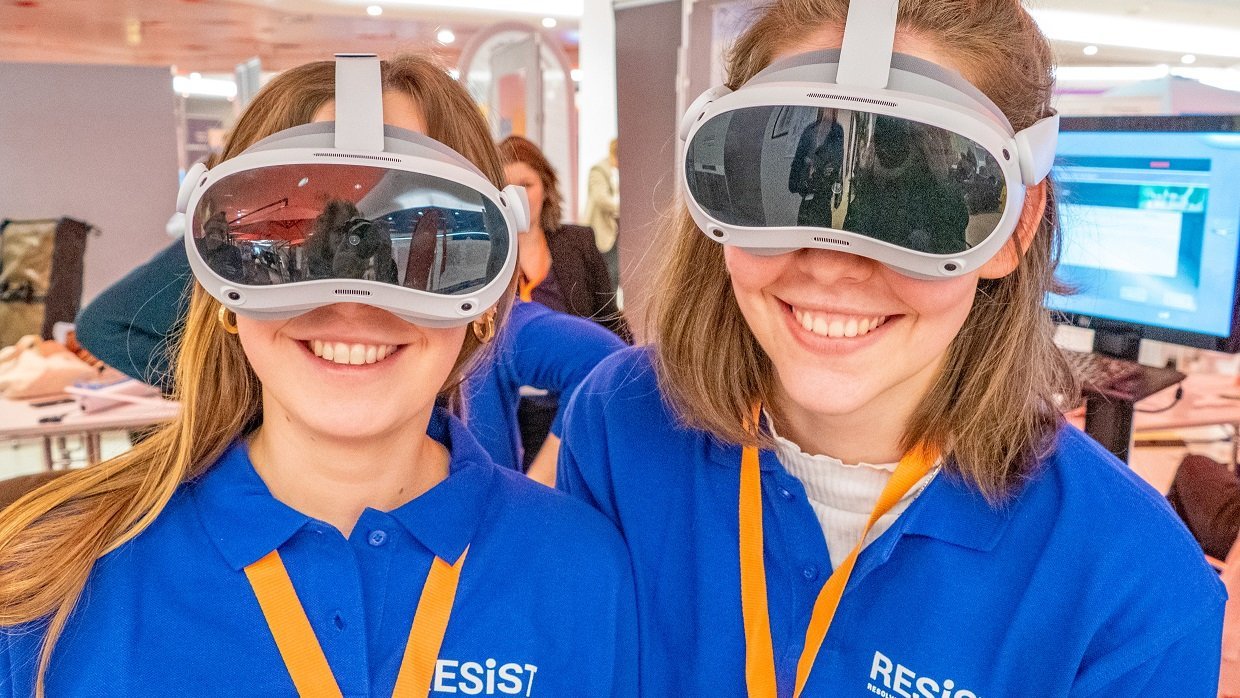 Zwei junge Frauen tragen VR-Brillen. 