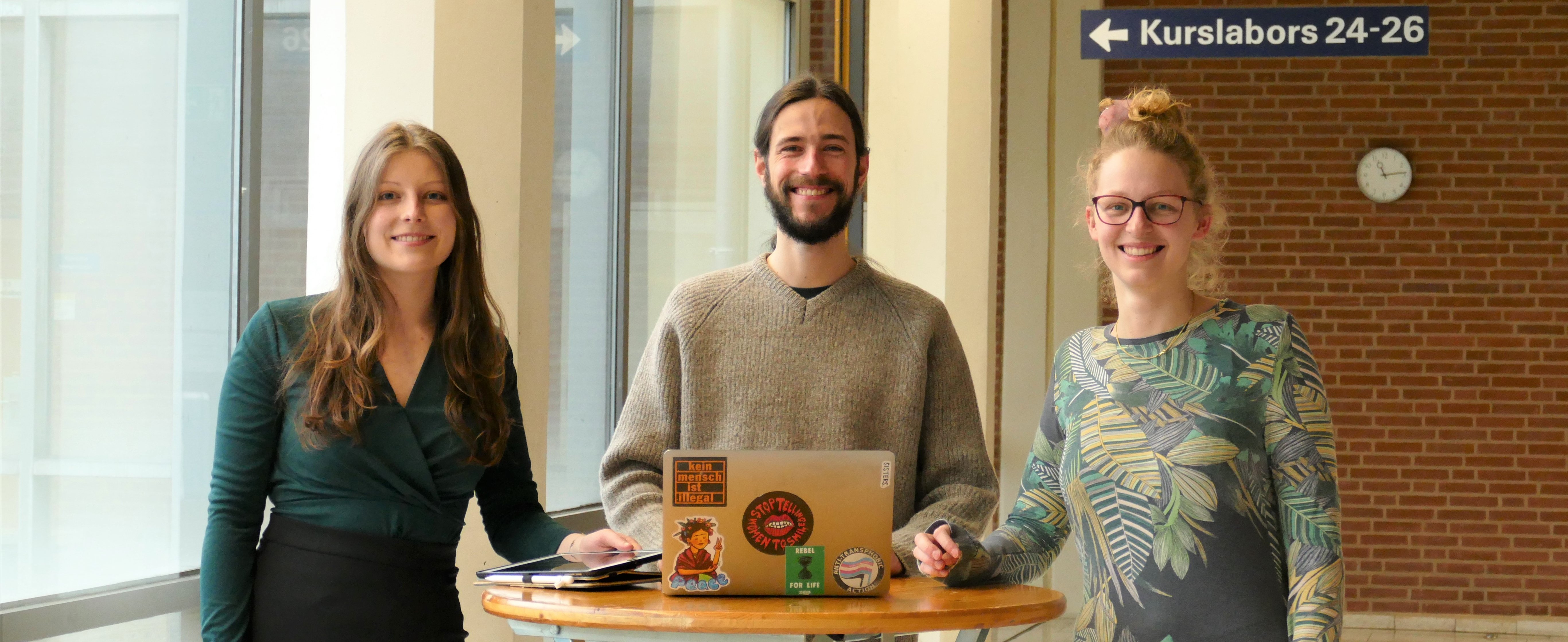 Studierende im Masterstudiengang Biomedizinische Datenwissenschaft stehen an einem Tisch zusammen: v.l.Julia Winkler, Adrian Schulz und Marie Mikuteit.