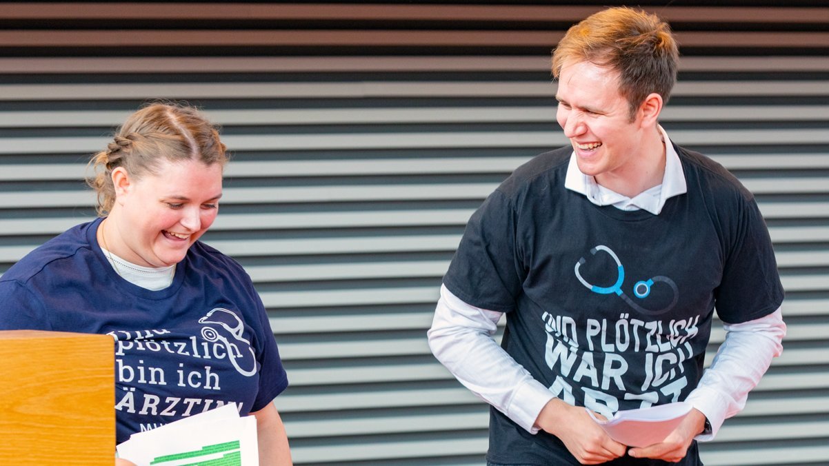 Die Absolvent:innen tragen ein T-Shirt mit der Aufschrift "Und plötzlich bin ich Arzt"