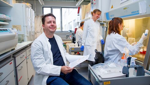 Professor Dr. Dr. Axel Schambach sitzt in einem Labor des MHH-Instituts für Experimentelle Hämatologie.
