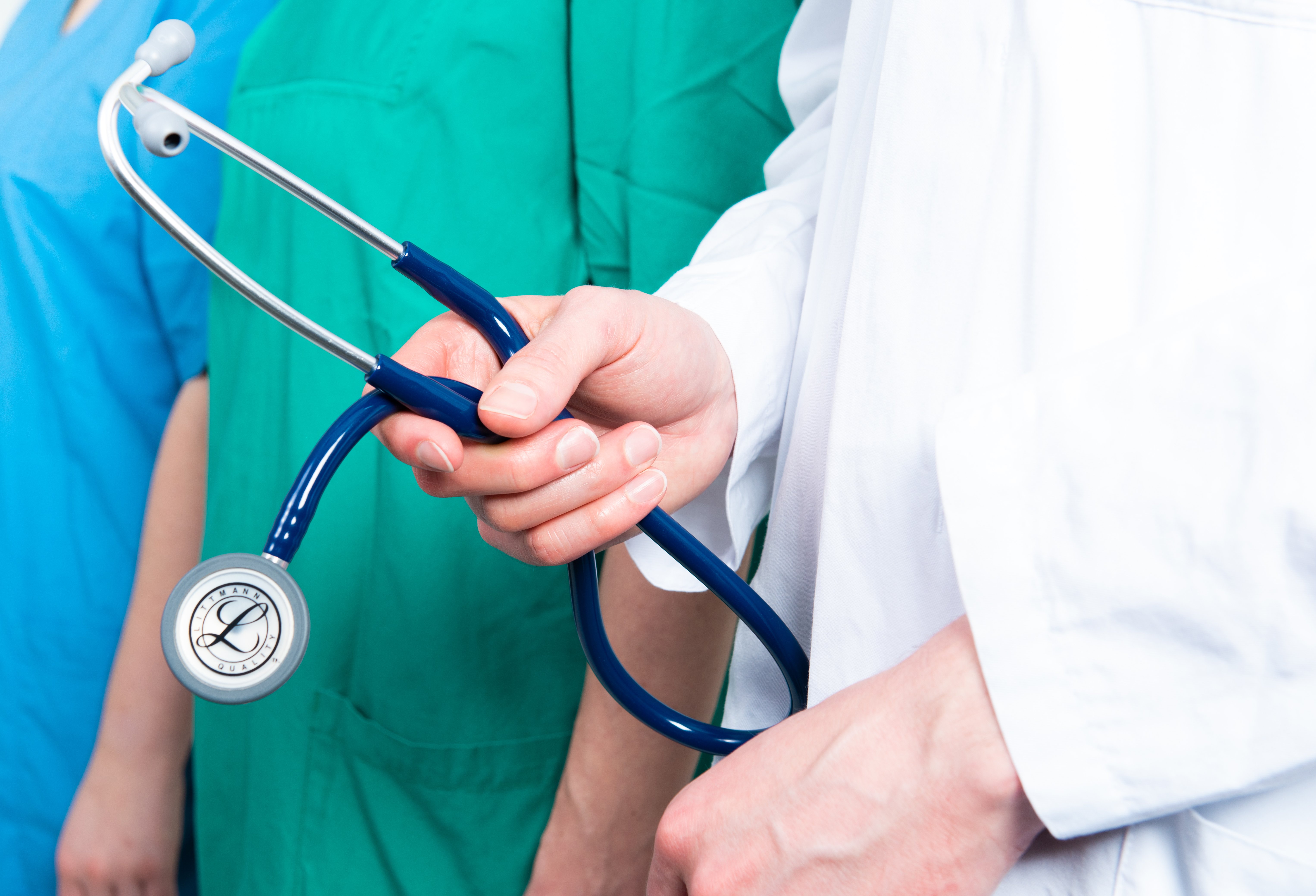 Ein Arzt in einem weißen Kittel mit einem Stetoskop in der Hand.
