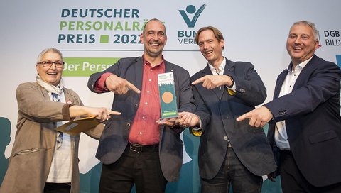 Nils Hoffmann und Christian Bock (in der Mitte des Bildes) nehmen den Preis entgegen. Mit ihnen freuen sich Elke Hannack, stellvertretende DGB-Vorsitzende und Daniel Merbitz, GEW-Bundesvorstand. 