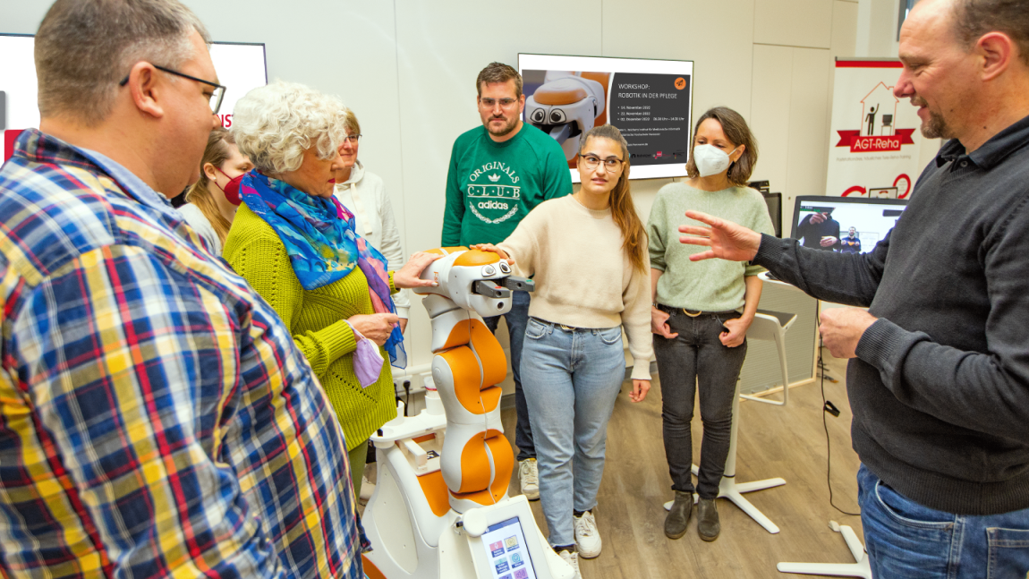 Mehrere Menschen stehen um Assistenzroboter Lio herum. 