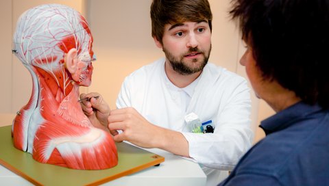 Ein Arzt erklärt einer Patientin in der Sprechstunde im Kopf-Hals-Tumorzentrum der MHH etwas an Hand eines Modells