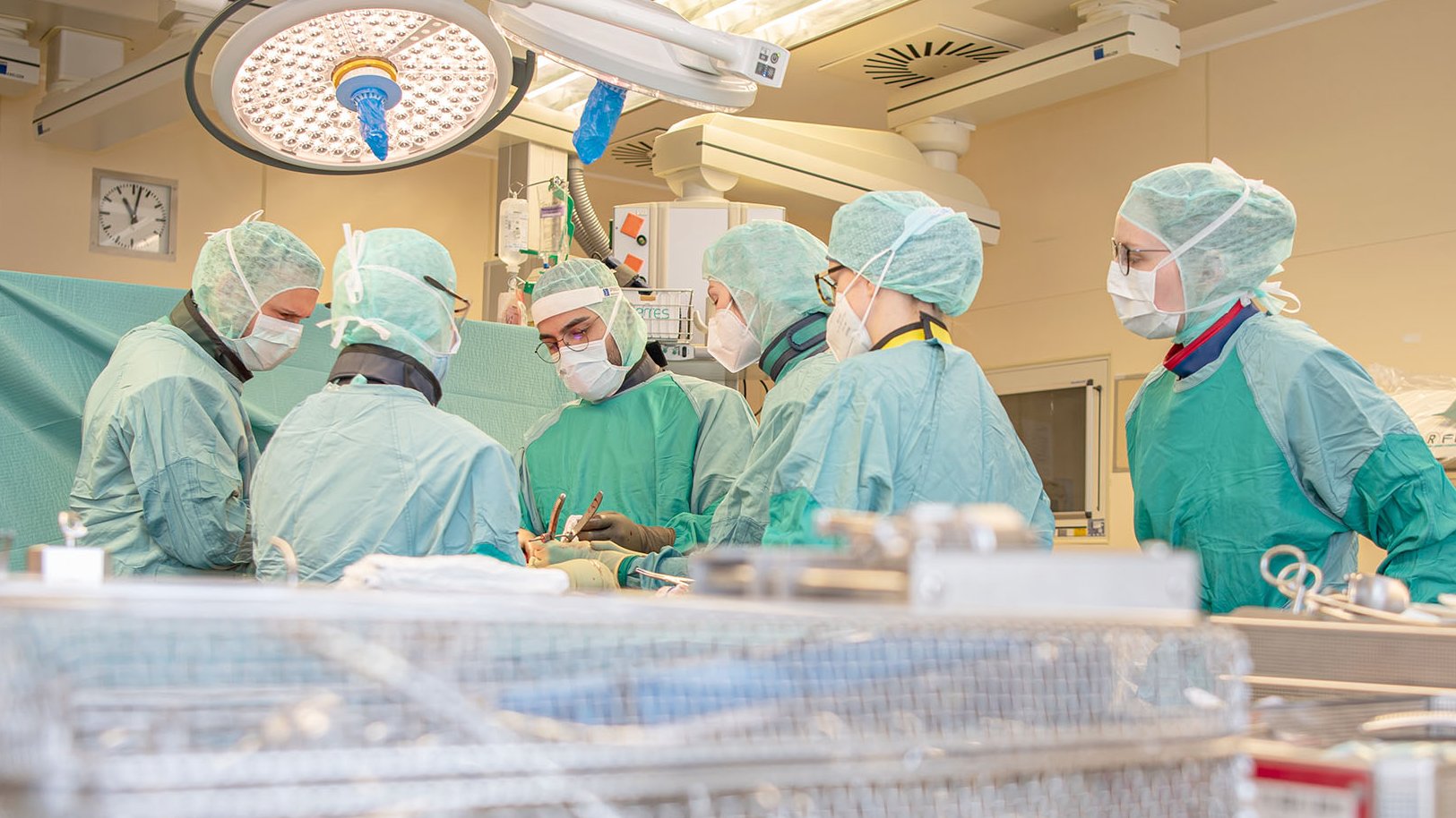 Ein Operateur und mehrere Assistent:innen während einer Operation