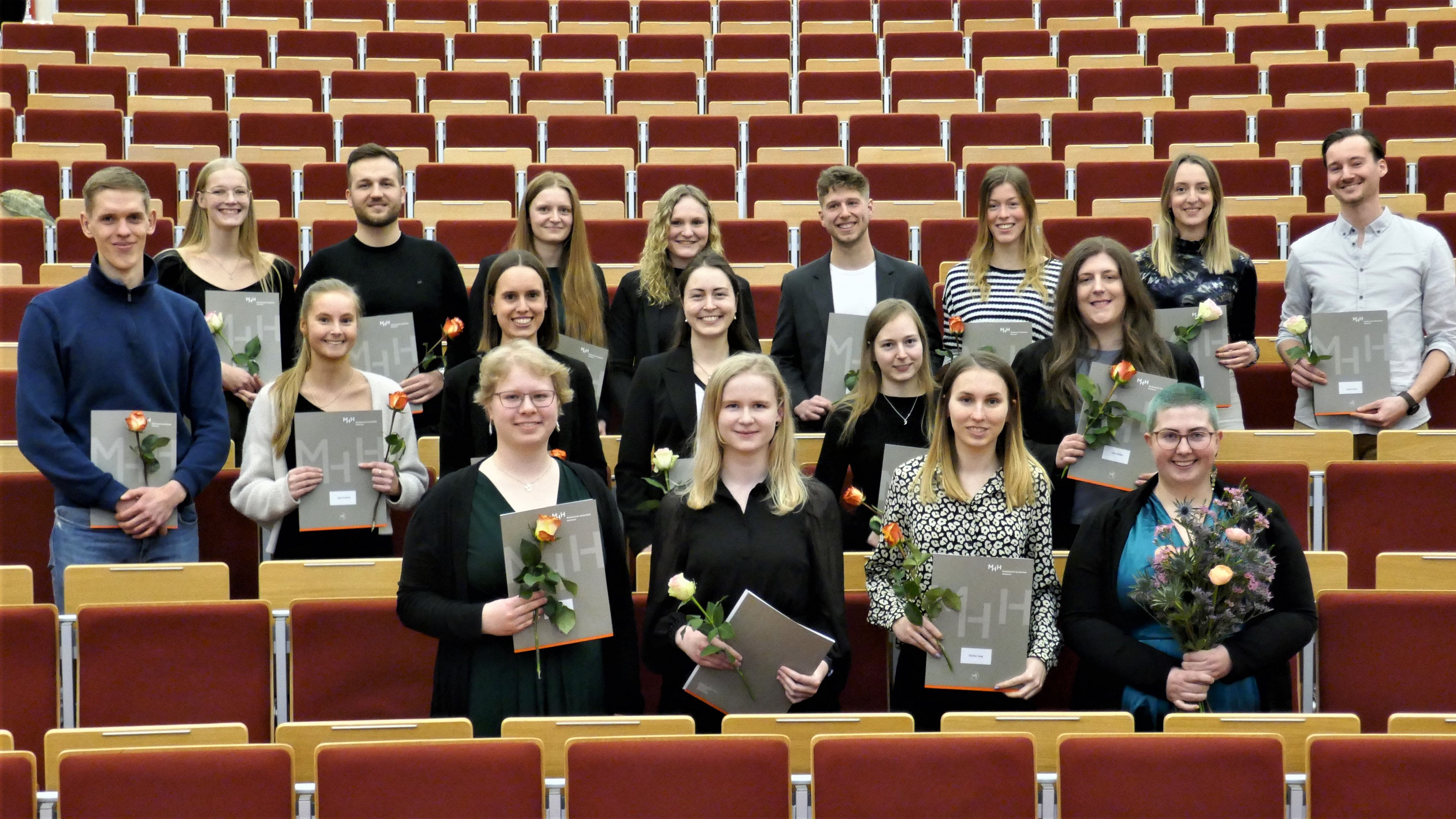 Mehrere Absolventen des Masterstudiengangs Biomedizin stehen nebeneinander in einem Hörsaal der MHH und halten ihre Urkunde in den Händen.