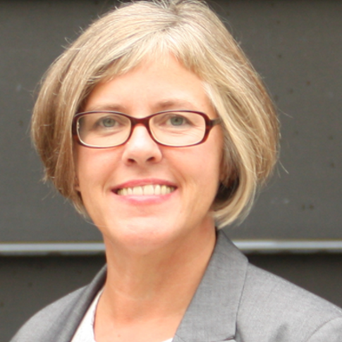 Porträtbild von Marianne Behrends, die eine weißes Oberteil und einen grauen Blazer trägt. 