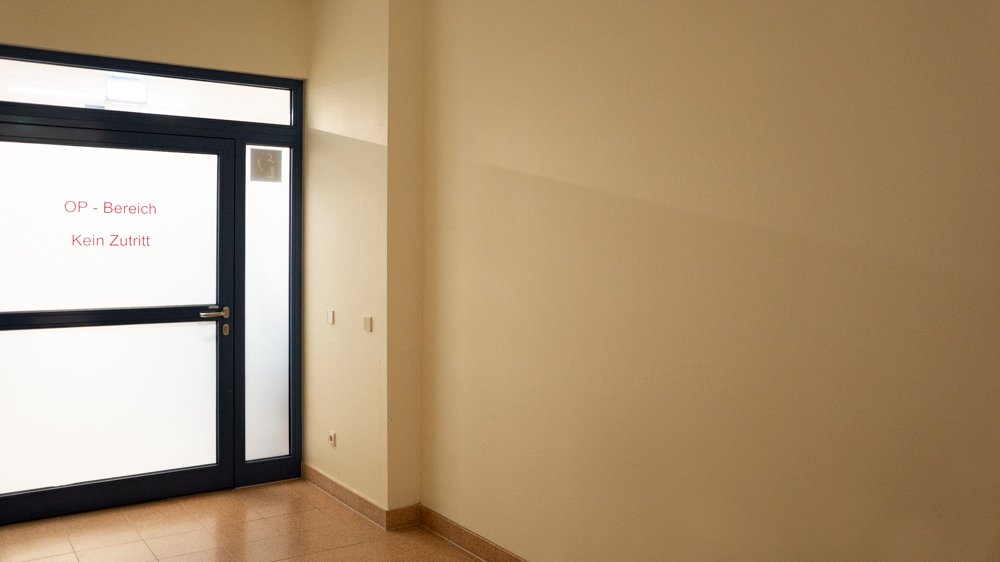 Im Vorraum des OP-Bereichs ist rechts neben dem Durchgang mit der Aufschrift "OP-Bereich" eine leere Wand zu sehen.