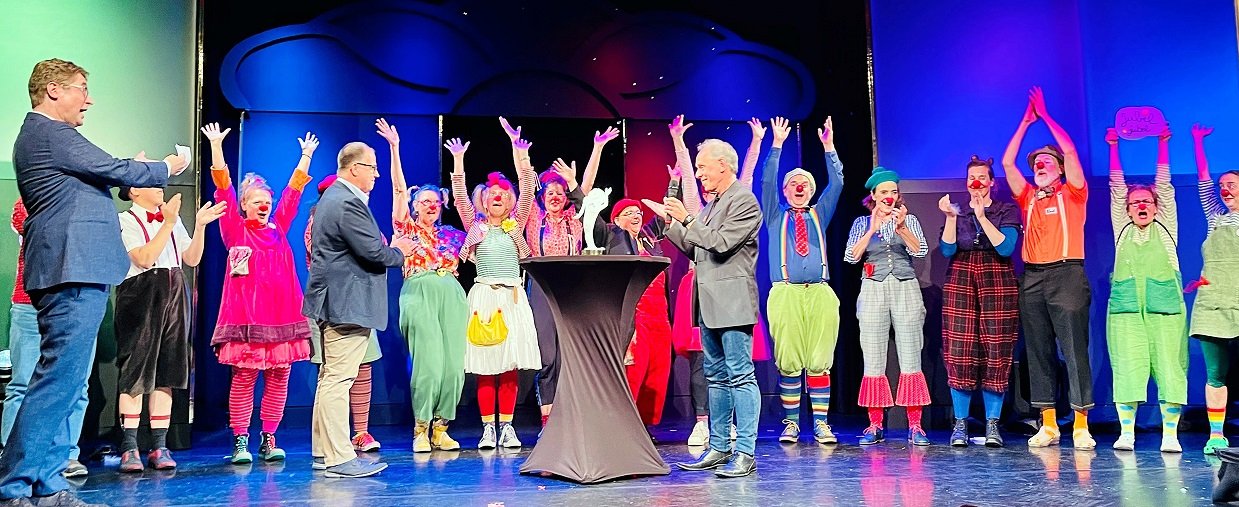 Gruppenbild mit den Clinic-Clowns, die auf der Bühne im Georgspalast in Hannover zusammenstehen und über den Preis jubeln..