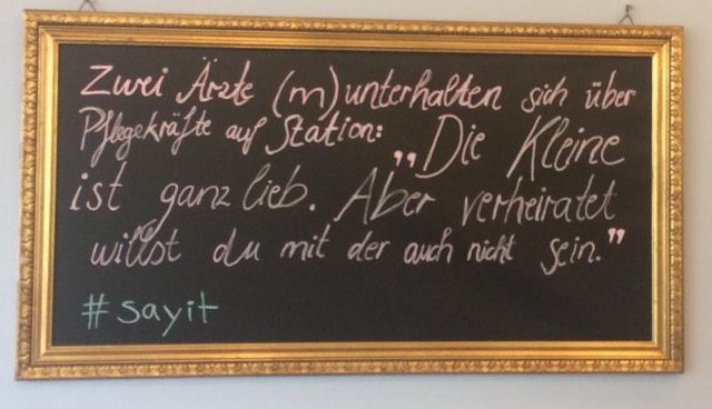 Goldenumrahmte Tafel mit der Aufschrift: Zwei Ärzte (männlich) unterhalten isch über Pflegekräfte auf Station: " Die Kleine ist ganz lieb. Aber verheiratet willst du mit der auch nicht sein." #sayit