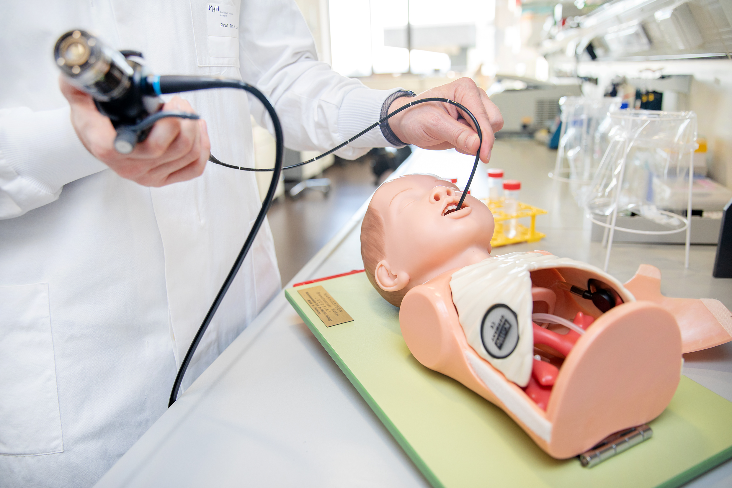 A child manikin can be seen with an endoscope inserted through its mouth.