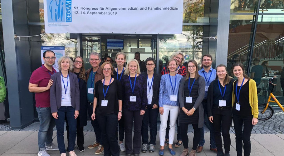 14 Mitarbeitende aus unserem Institut für Allgemeinmedizin und Palliativmedizin stehen vor dem Eingang des Kongressgebäudes in Erlangen.