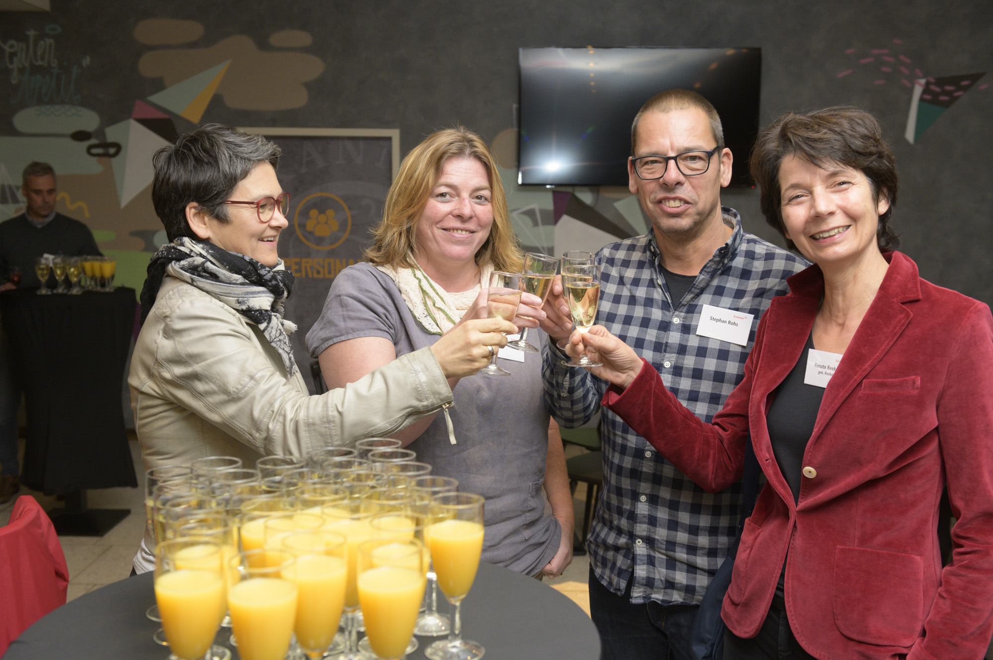 Teilnehmer stoßen mit Sekt und Orangensaft an.