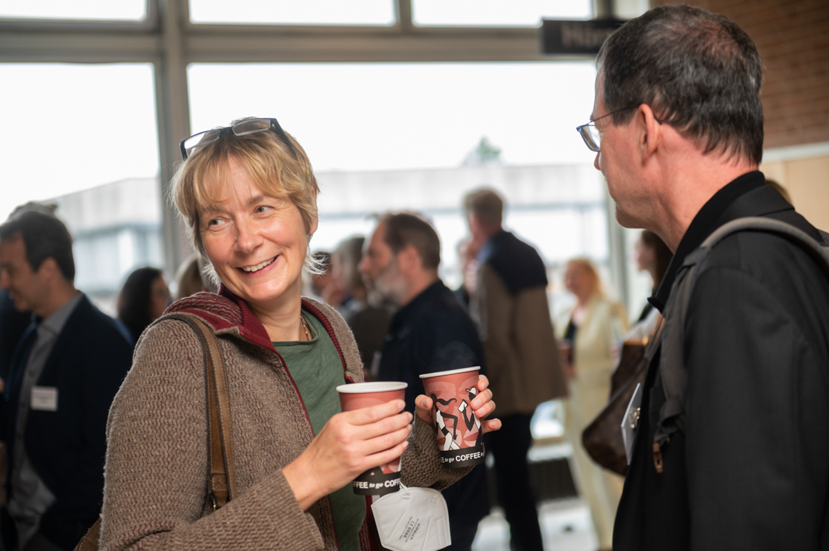 Eine Teilnehmerin hält zwei Kaffeebecher in der Hand.