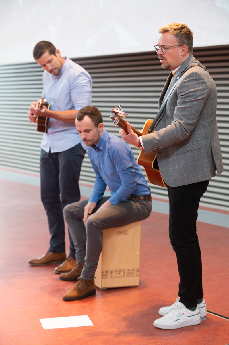 Die drei Musiker spielen Gitarre, Cajon und eine kleine südamerikanische Gitarre. 