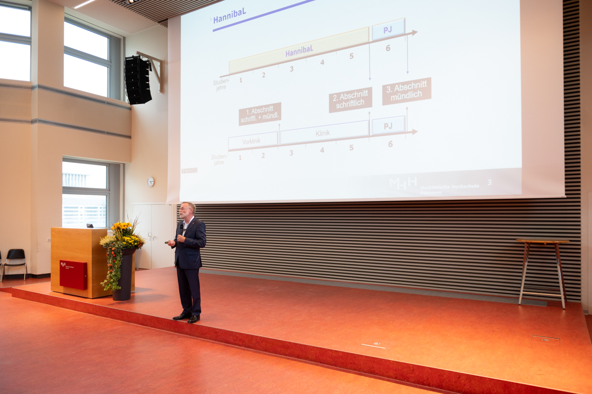 Studiendekan steht im Hörsaal vor der Leinwand