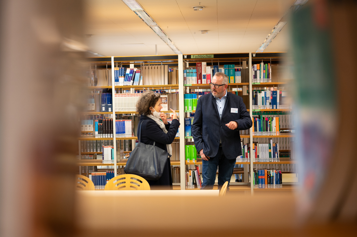 Durch eine Lücke im Bücherregal wurden zwei Jubilare fotografiert.