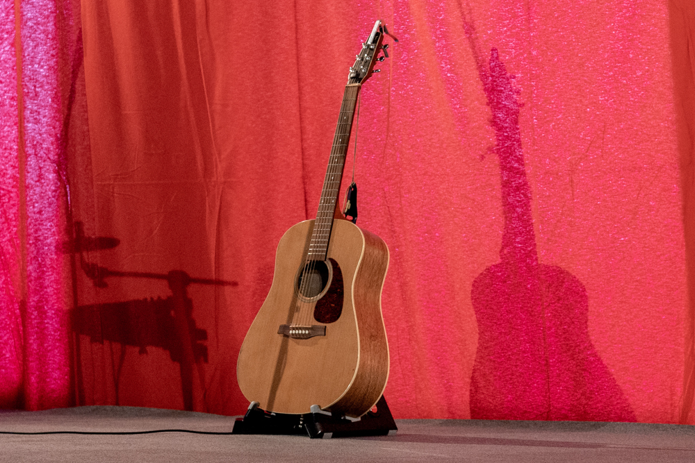 Gitarre im Gitarrenständer auf der Bühne