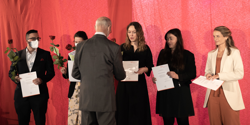© Annika Morchner, MHH Professor Piepenbrock übergibt einer Absolventin eine rote Rose.