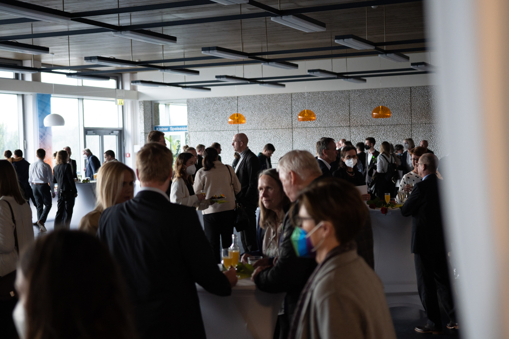 © Annika Morchner, MHH Die Gäste stehen verteilt an Stehtischen und essen und trinken.