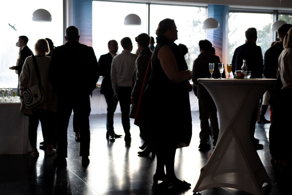 © Annika Morchner, MHH Die Gäste stehen beim Sektempfnag im Gegenlicht.